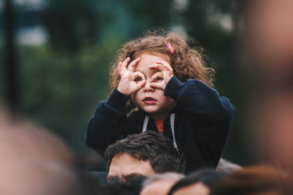little girl looking through her hands like binoculars